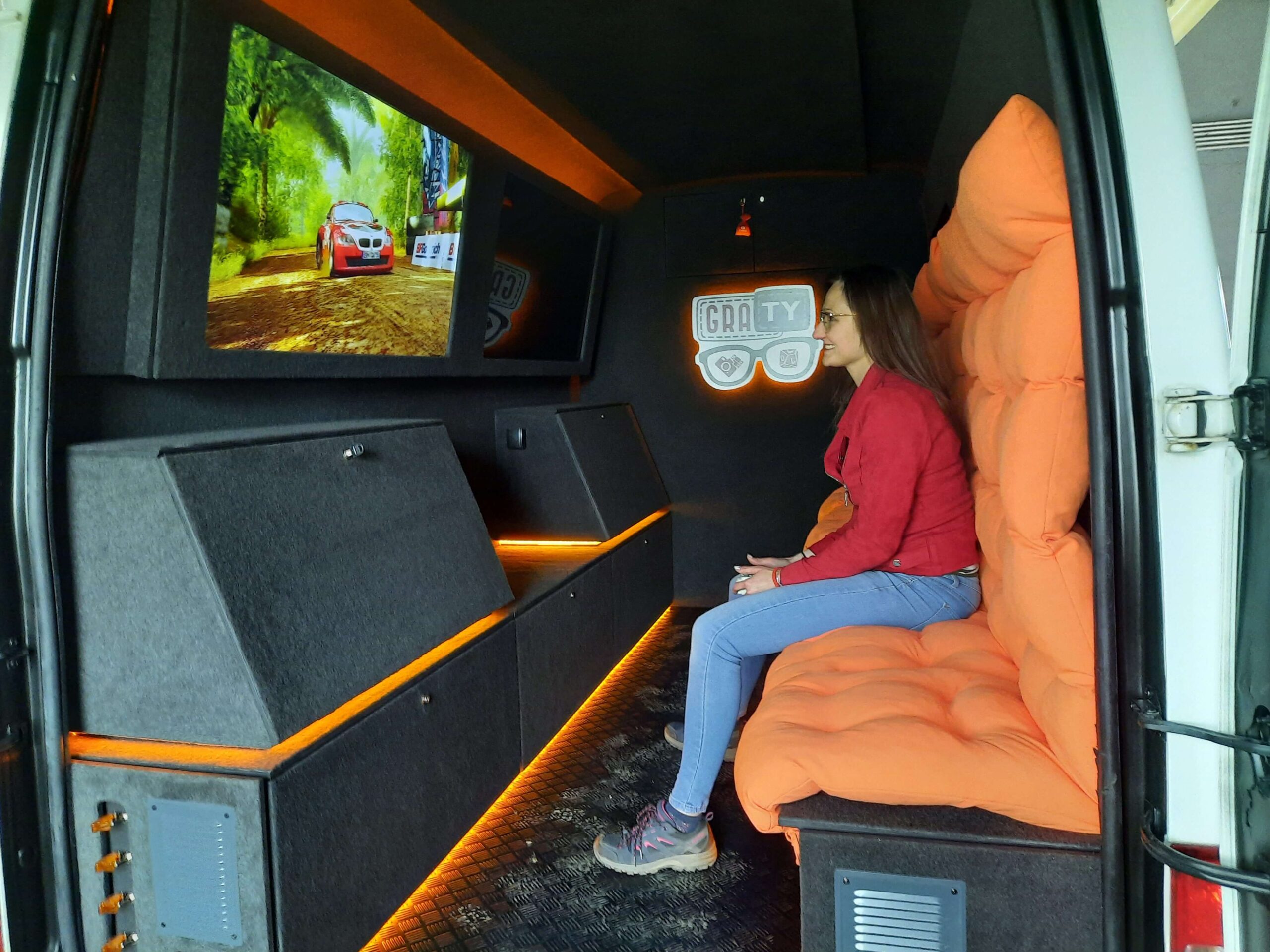 Młoda kobieta gra na konsoli we wnętrzu GRAtoWOZu