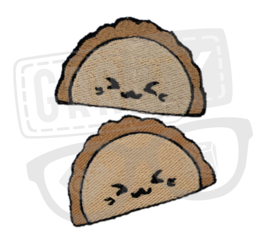 Dwie naszywki w kształcie pierogów: jasnobrązowe pierogi z ciemnobrązowymi brzegami i czarnymi, haftowanymi twarzami, ułożone jeden nad drugim na białym tle.