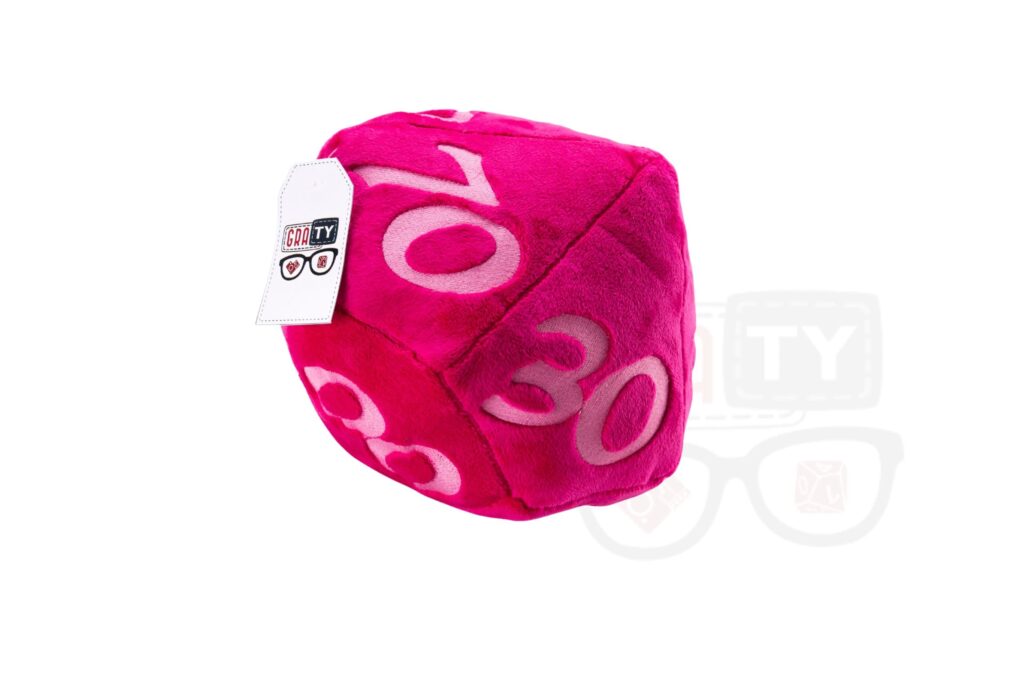 Pluszowa kostka RPG: różowa, dwudziestościenna kostka z białymi cyframi 10, 30 i 8, z widoczną metką, leżąca na białym tle.