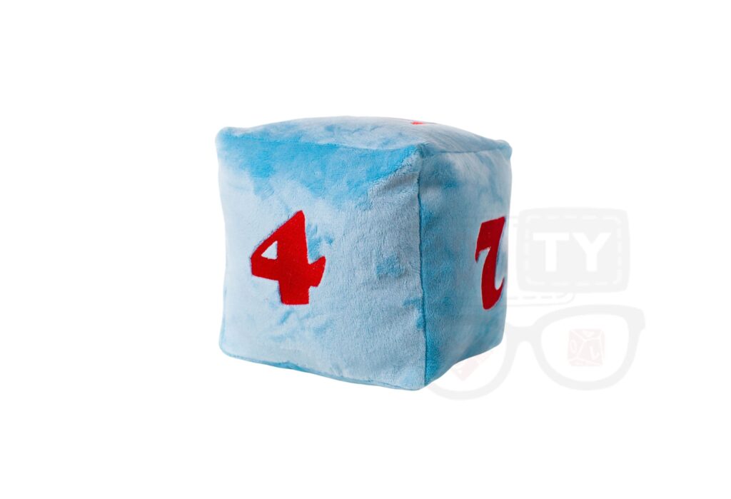 Pluszowa kostka k6RPG: jasnoniebieska, sześcienna kostka z czerwonymi cyframi 4 i 7, leżąca na białym tle.