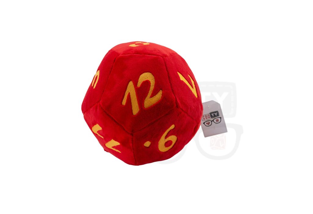 Pluszowa kostka k12 RPG: czerwona, dwunastościenna kostka z żółtymi cyframi 6, 12 i innymi, z widoczną metką, leżąca na białym tle.