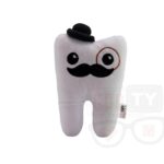 Pluszowy ząb z kapeluszem i monoklem, leżący na białym tle.